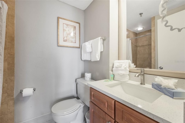 bathroom featuring vanity, toilet, and a tile shower