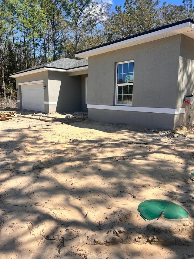 view of front facade featuring stucco siding and a garage
