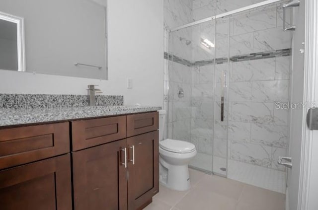 bathroom with toilet, tile patterned floors, vanity, and a shower stall