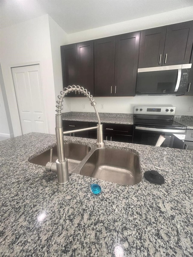 9451 N Emellia Ave, Citrus Springs, FL 34433 - kitchen view of stainless steel electric range oven, a sink, and dark stone countertops