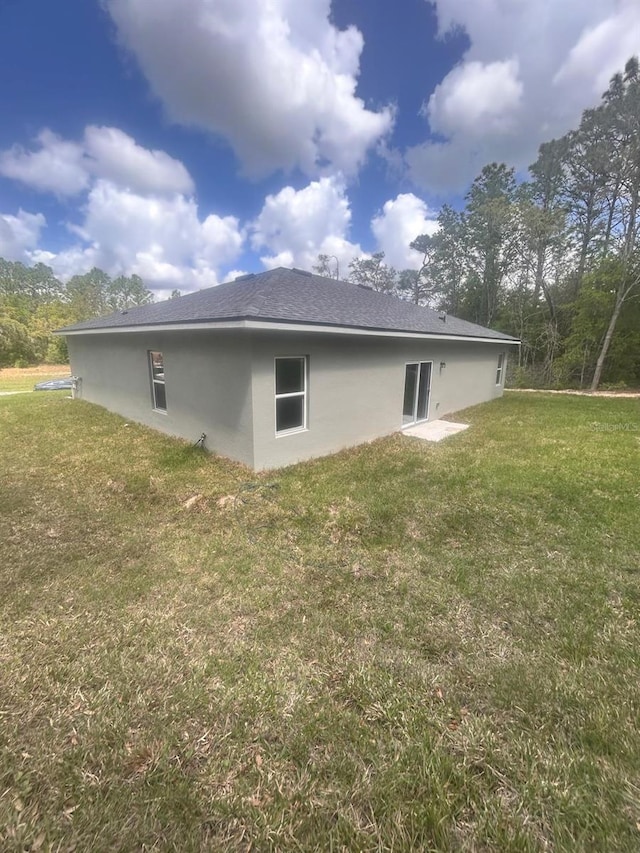 9451 N Emellia Ave, Citrus Springs, FL 34433 - rear view of property with a yard and stucco siding