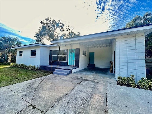 single story home with an attached carport, concrete driveway, and a front yard