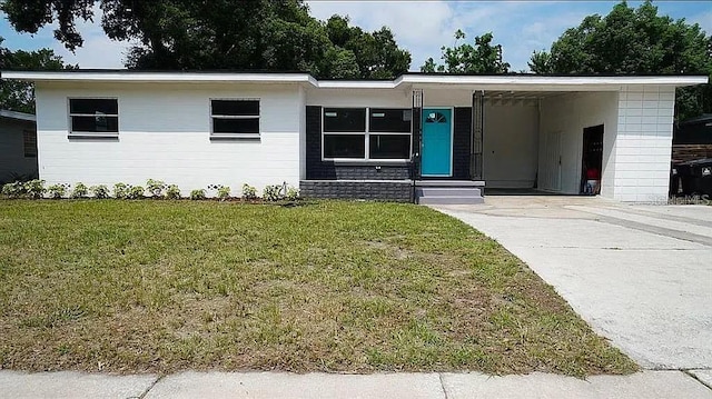 view of front of house with driveway, a front lawn, and a carport