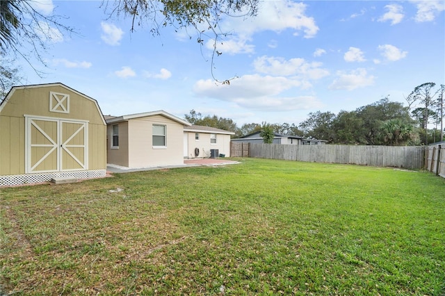 view of yard featuring an outbuilding, a patio area, a fenced backyard, and a storage shed