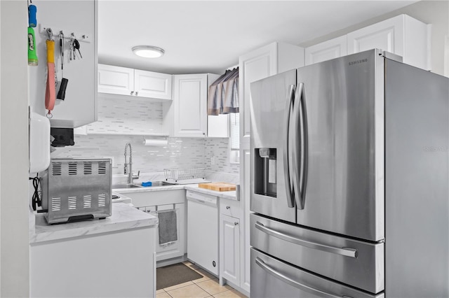 kitchen with stainless steel refrigerator with ice dispenser, decorative backsplash, white cabinetry, a sink, and dishwasher