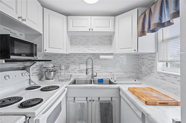 kitchen featuring tasteful backsplash, white appliances, white cabinetry, and a sink