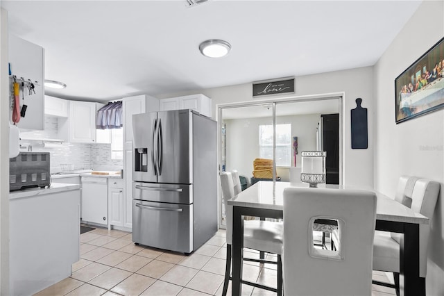 kitchen featuring stainless steel fridge, white dishwasher, white cabinets, and light countertops