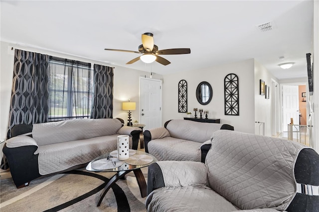 living area featuring visible vents and a ceiling fan