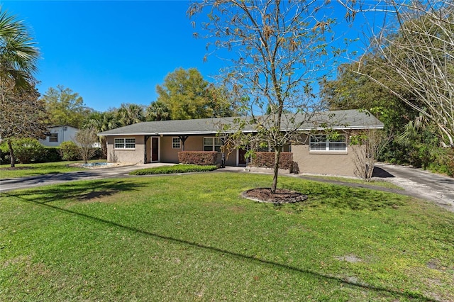 ranch-style house with stucco siding, a front lawn, and driveway