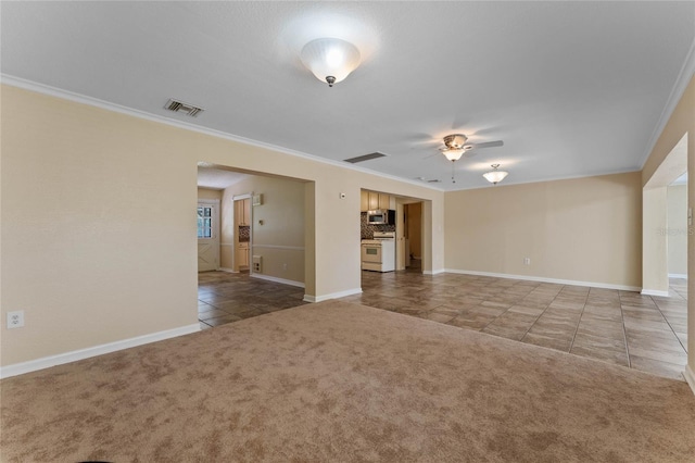 unfurnished living room with tile patterned flooring, a ceiling fan, carpet, and ornamental molding