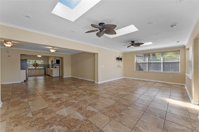 unfurnished living room with a skylight, baseboards, and ornamental molding