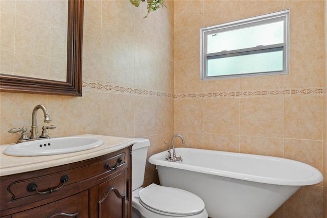 bathroom with a freestanding tub, toilet, tile walls, and vanity