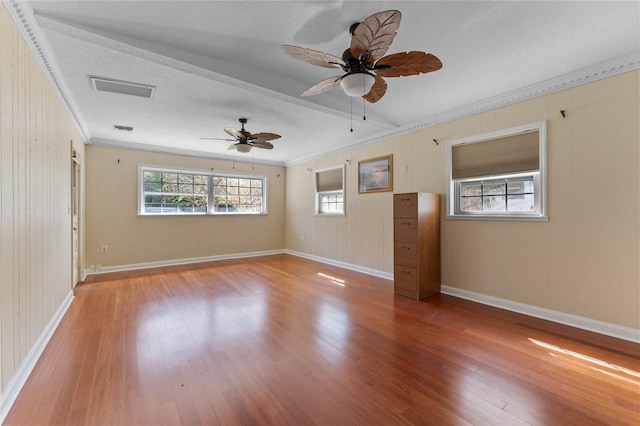 unfurnished room with visible vents, baseboards, hardwood / wood-style floors, and ornamental molding