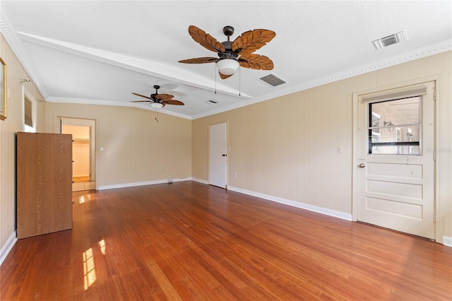 unfurnished room with ceiling fan, wood finished floors, visible vents, and ornamental molding