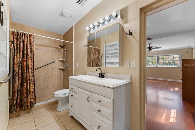 bathroom with vanity, toilet, visible vents, and a tile shower