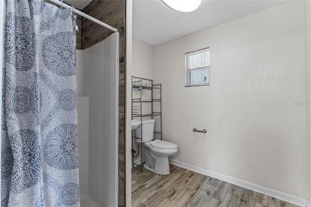 full bath with curtained shower, baseboards, toilet, and wood finished floors