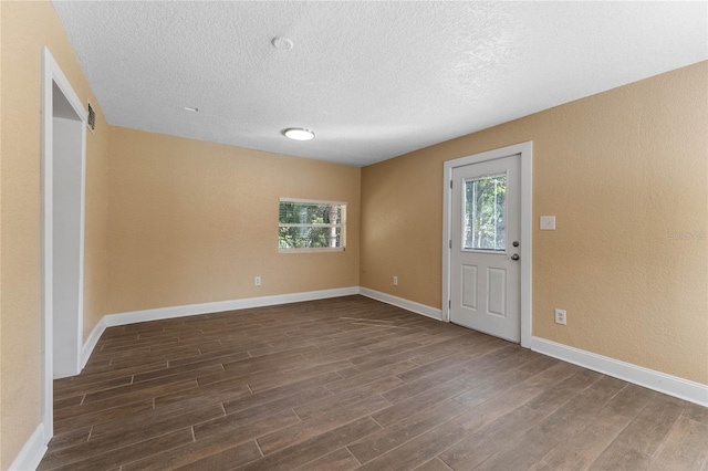 foyer featuring visible vents, baseboards, a textured ceiling, and dark wood-style flooring