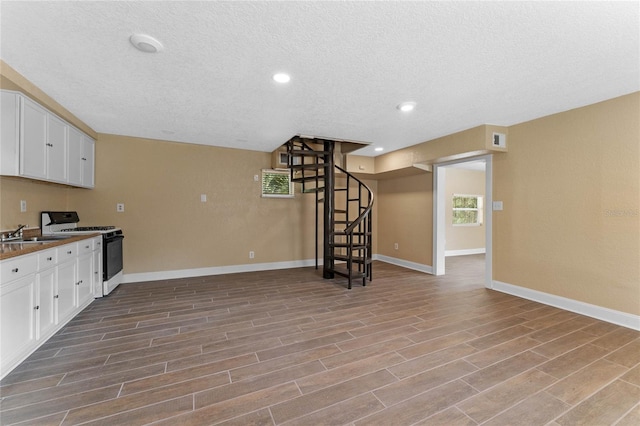 kitchen with wood finished floors, visible vents, gas range, and white cabinets