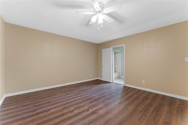 spare room with baseboards, a textured ceiling, dark wood finished floors, and a ceiling fan