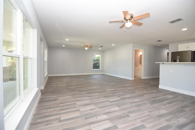 unfurnished living room with light wood finished floors, baseboards, a ceiling fan, and recessed lighting