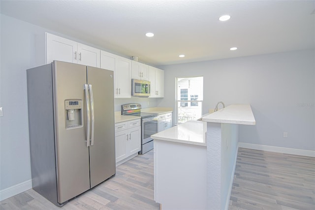 kitchen featuring light wood-style floors, white cabinetry, stainless steel appliances, and light countertops