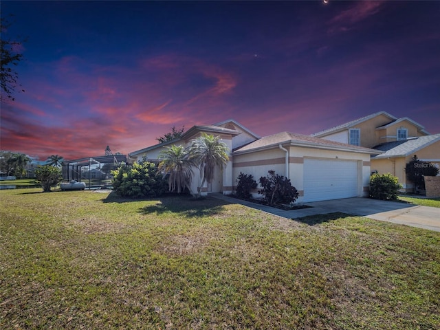 view of front of property featuring a front yard, driveway, an attached garage, and stucco siding