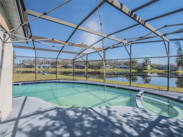 view of swimming pool with a water view, glass enclosure, a pool with connected hot tub, and a residential view