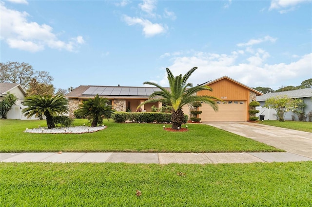 view of front facade featuring roof mounted solar panels, driveway, a front lawn, and an attached garage