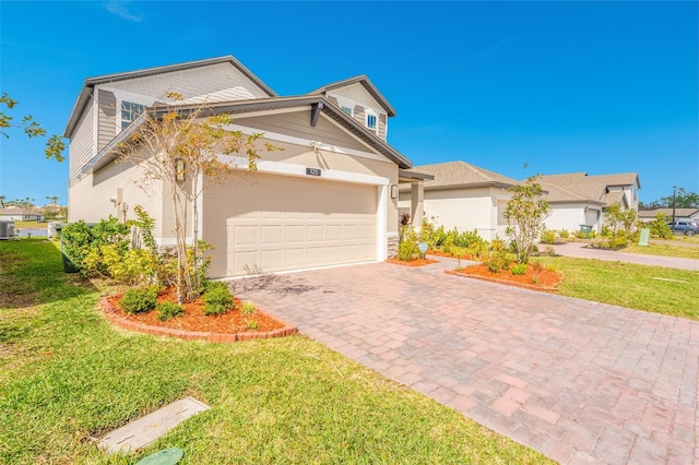 traditional-style house with an attached garage, central air condition unit, decorative driveway, and a front yard