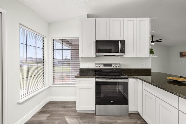 kitchen with appliances with stainless steel finishes, white cabinetry, and dark wood-style floors