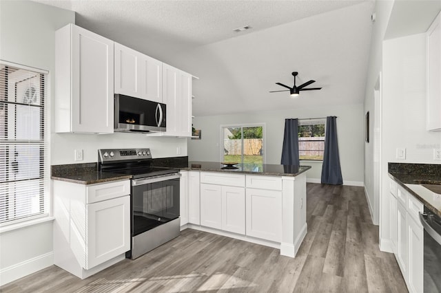 kitchen with a peninsula, light wood-style flooring, appliances with stainless steel finishes, and white cabinets