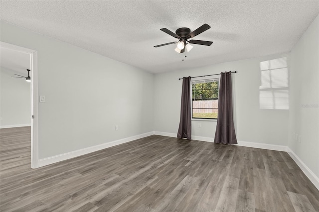 unfurnished room with ceiling fan, wood finished floors, and baseboards