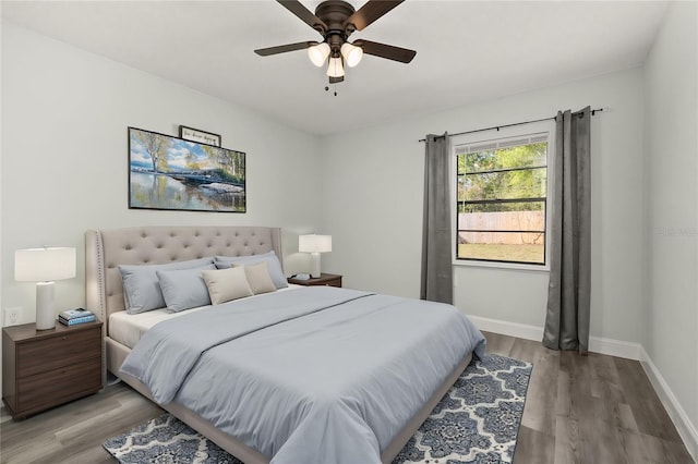 bedroom with wood finished floors, a ceiling fan, and baseboards