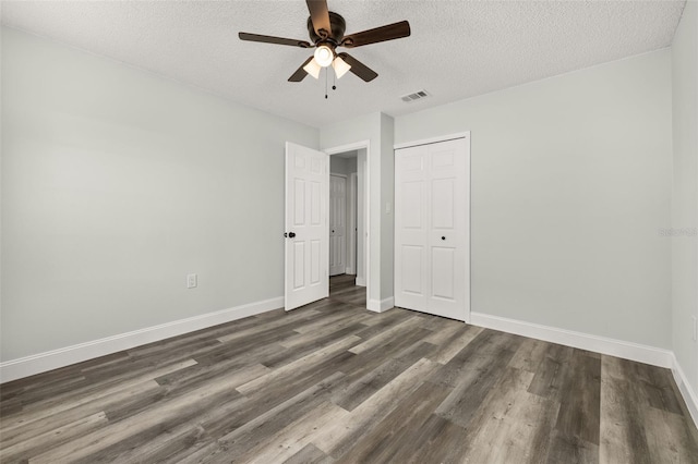 unfurnished bedroom with baseboards, a closet, visible vents, and wood finished floors