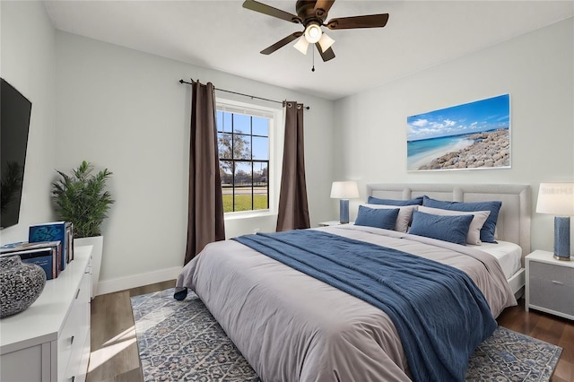 bedroom with dark wood-type flooring, ceiling fan, and baseboards