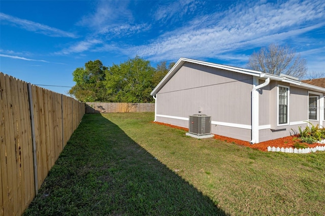 view of property exterior with central air condition unit, a fenced backyard, and a lawn