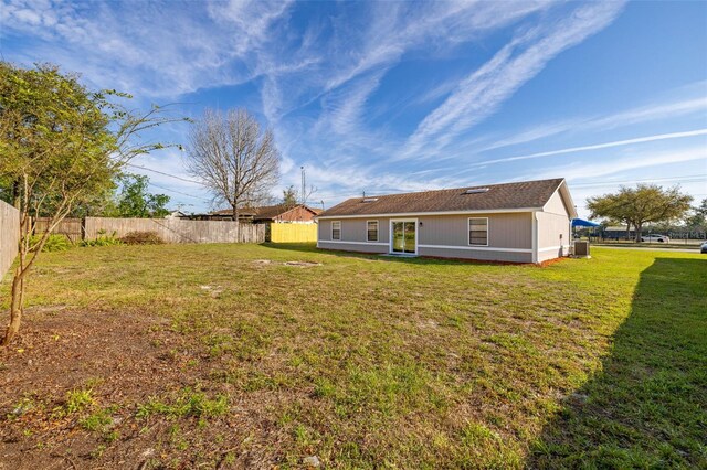 rear view of house with a yard and fence