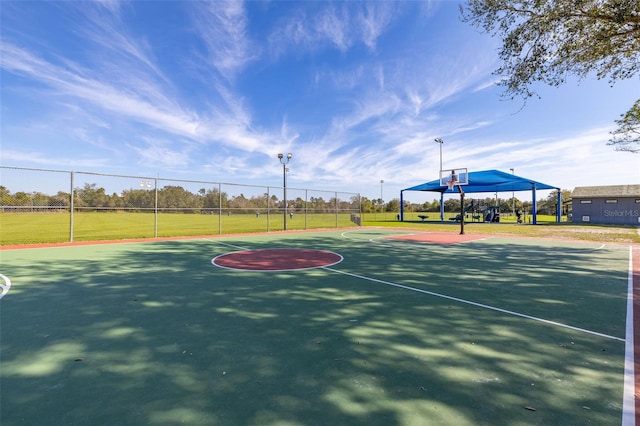 view of sport court featuring community basketball court, fence, and a yard