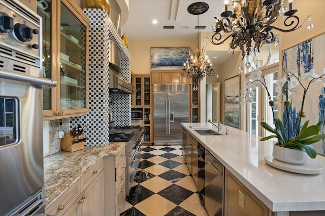 1400 Alabama Dr, Winter Park, FL 32789 - kitchen with glass insert cabinets, premium appliances, a sink, a chandelier, and decorative backsplash
