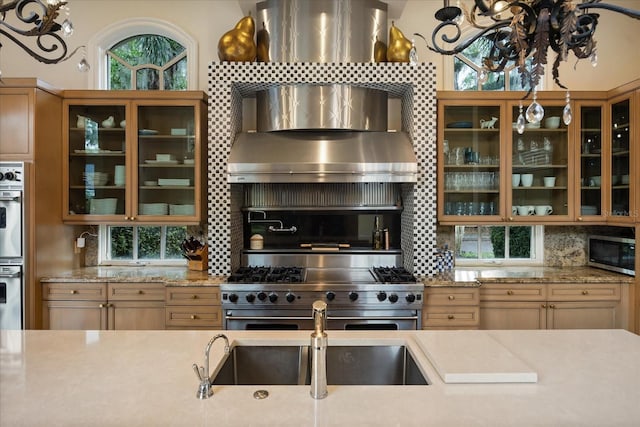 1400 Alabama Dr, Winter Park, FL 32789 - kitchen with tasteful backsplash, glass insert cabinets, wall chimney range hood, a chandelier, and stainless steel appliances