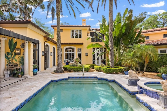 1400 Alabama Dr, Winter Park, FL 32789 - rear view of property featuring a chimney, a tile roof, stucco siding, an outdoor pool, and an in ground hot tub