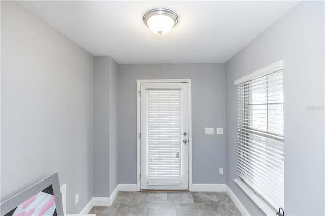 doorway featuring baseboards and a textured ceiling