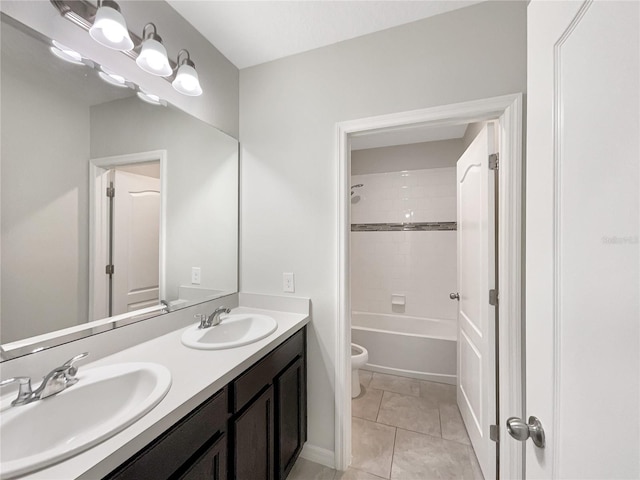 bathroom featuring double vanity, toilet, a sink, and tile patterned floors