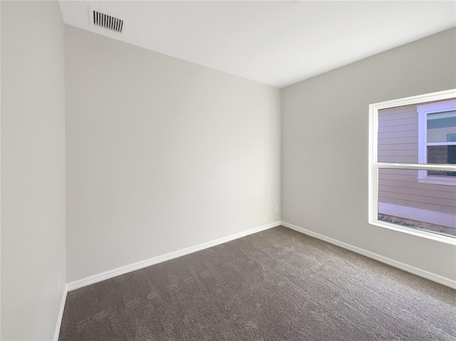 empty room with carpet, baseboards, and visible vents