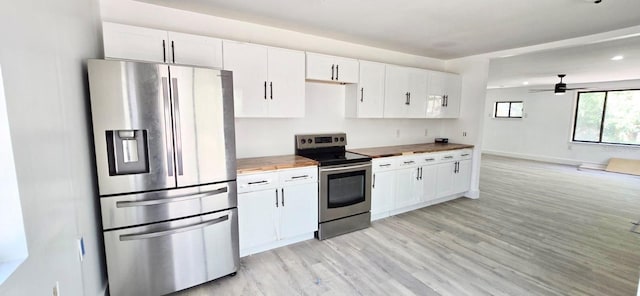 kitchen with stainless steel appliances, butcher block countertops, light wood-style flooring, and white cabinetry