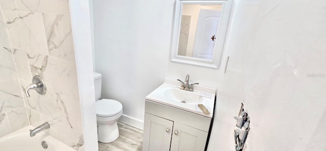 bathroom featuring shower / bath combination, toilet, vanity, wood finished floors, and baseboards