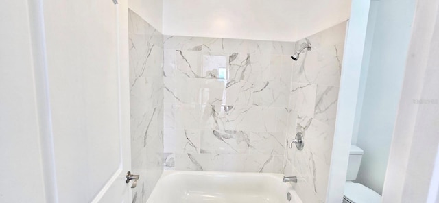 bathroom featuring washtub / shower combination and toilet