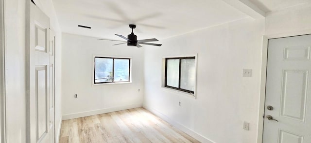 interior space with a ceiling fan, beamed ceiling, light wood-style flooring, and baseboards