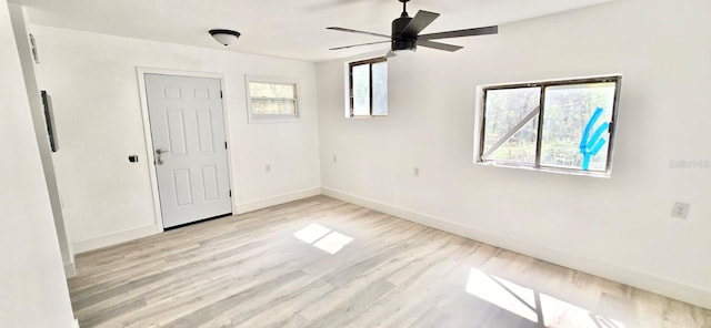 spare room with ceiling fan, light wood-style flooring, and baseboards