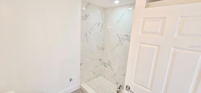 full bath featuring baseboards and a marble finish shower